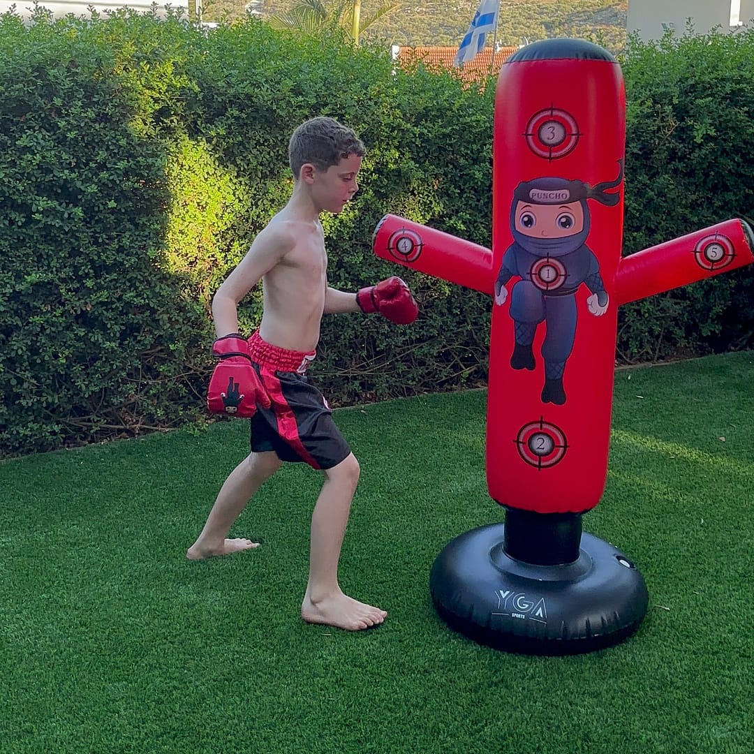 kid punching bag with boxing gloves outdoor